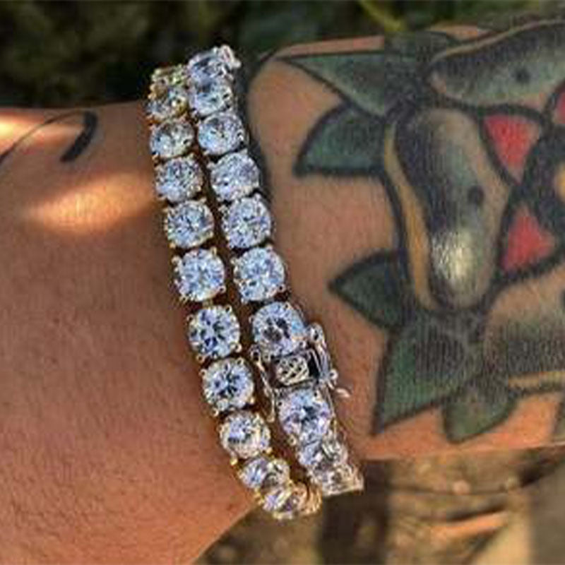 Diamond-studded bracelets adorn a wrist featuring a colorful tattoo underneath.